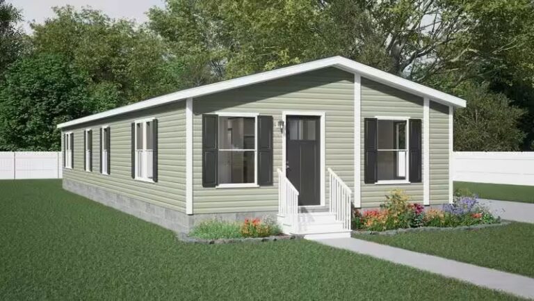 Green single-wide mobile home with white trim, black shutters, and front flower beds on a lawn
